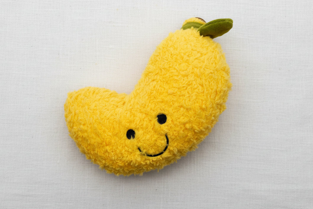Yellow plush toy shaped like a banana with a smiley face