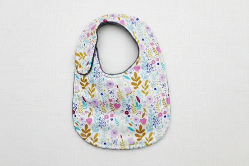 Load image 1 in gallery view. Floral patterned baby bib on a white background