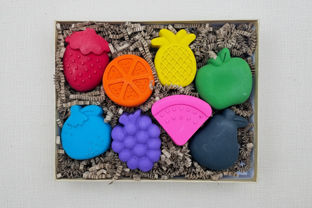 Colorful fruit-shaped crayons in a box 