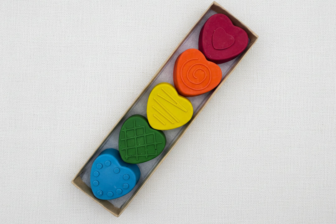 Set of colorful heart-shaped crayons in a box 