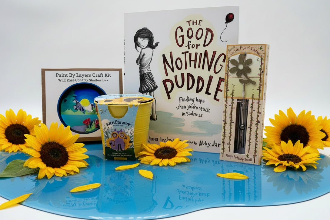 Collection of children's book, flower growing kit, wind chime and craft on tan background