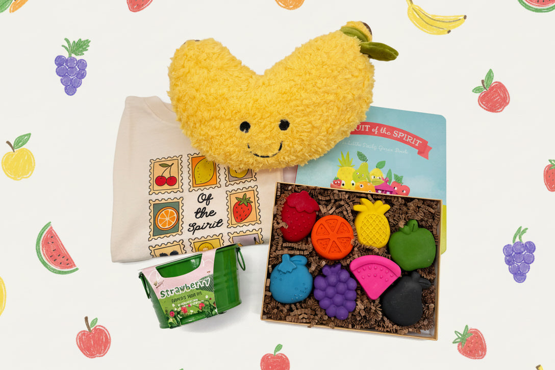 Banana plush toy with a t-shirt, book, strawberry growing kit, and fruit-shaped crayons 
