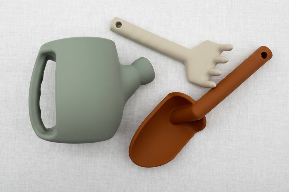 Set of children's gardening tools including a watering can, spade, and claw