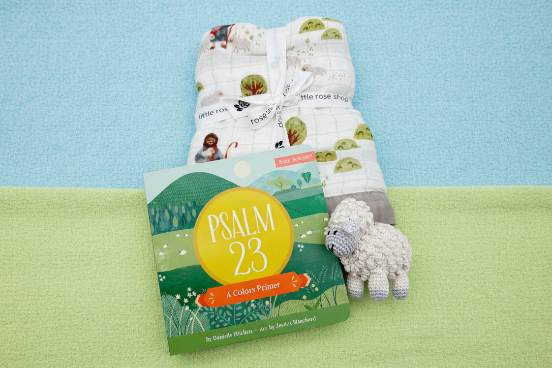 Children's book titled 'Psalm 23' with a soft toy sheep and baby blanket 