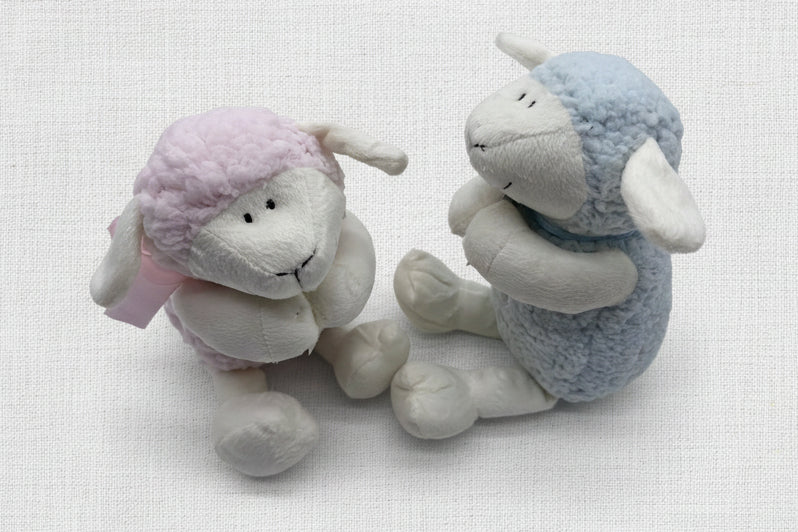 Two plush sheep toys, one pink and one blue