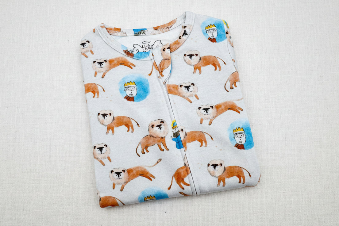 Folded baby onesie with lion pattern on a white background
