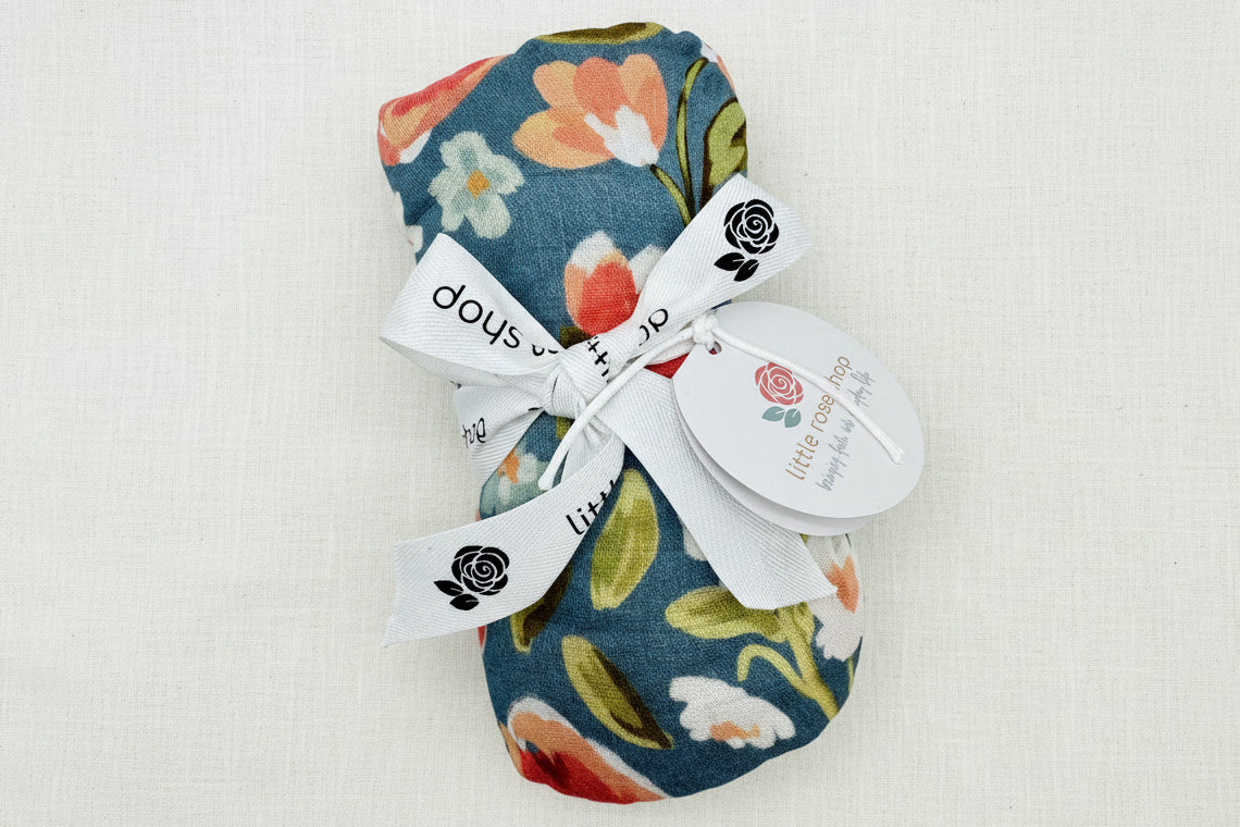 Floral-patterned swaddle blanket tied up with white ribbon 
