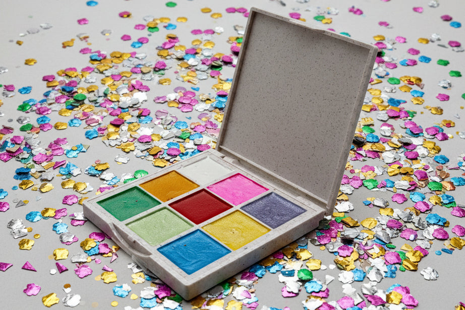 Colorful watercolor palette with a textured box on a background with colorful confetti